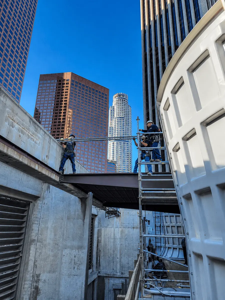 Scaffolding 24/7 crew on scaffolding between high-rise towers in downtown Los Angeles